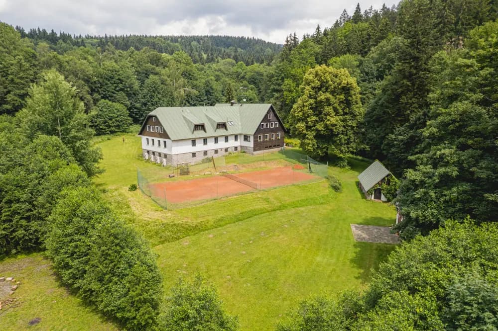 Letecký pohled na Hotel pod Pralesem, tenisový kurt a okolní les v Mladých Bukách