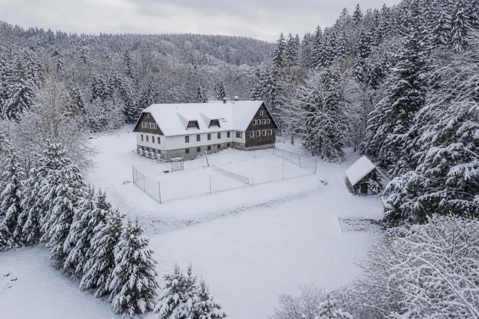 Hotel pod Pralesem v zasněžené krajině v Mladých Bukách